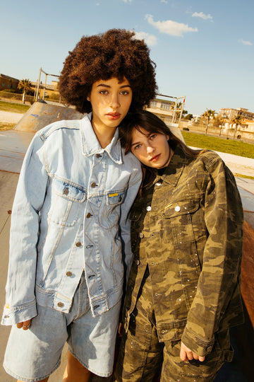 Two persons dressed in denim - a faded denim and a camouflage denim