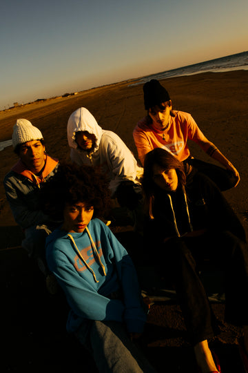 Group of people sitting on a beach at sunset