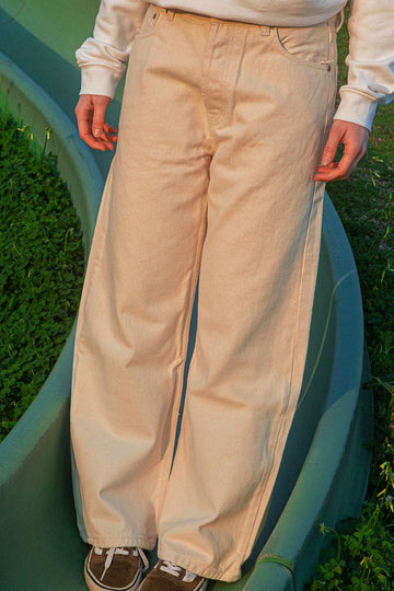 Wide flare pants worn by a person standing on a green surface with grass in the background