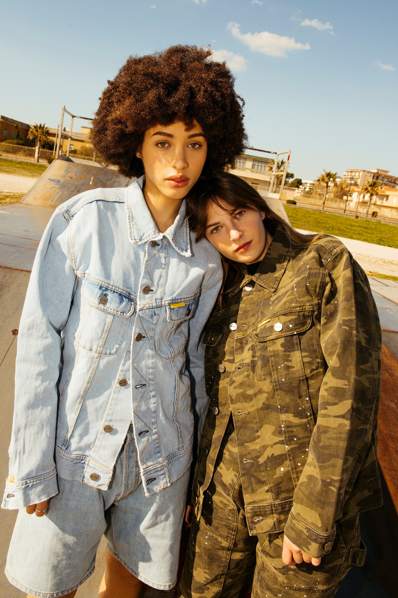 Two persons dressed in denim - a faded denim and a camouflage denim