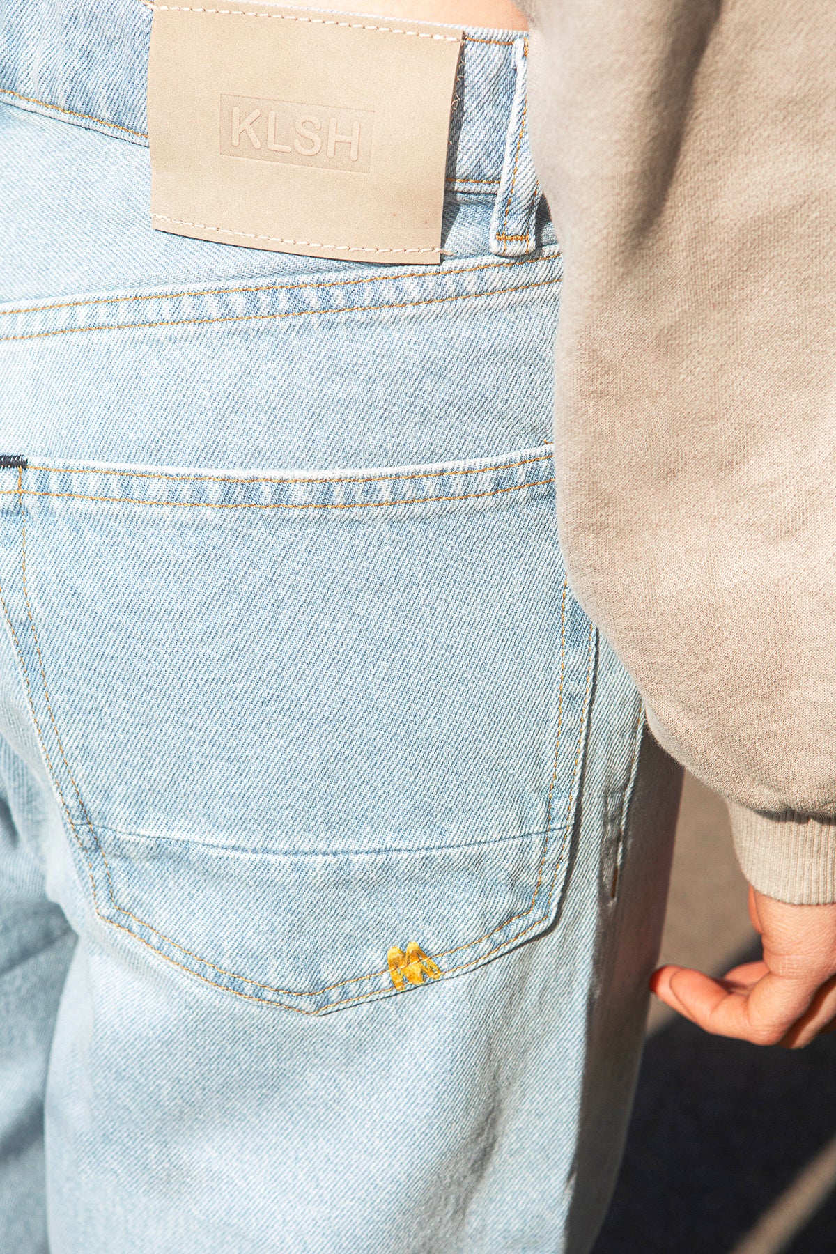 Light blue jeans with a brand label and a small yellow flower design.