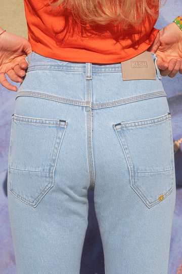 MORIS slim-fit jeans with KLSH brand label on a colorful background