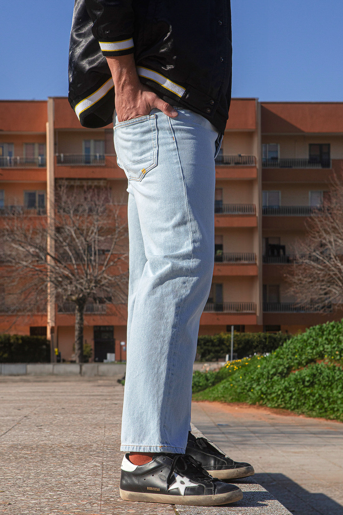Person wearing the MORIS slim fit jeans and black shoes standing outdoors with a building in the background