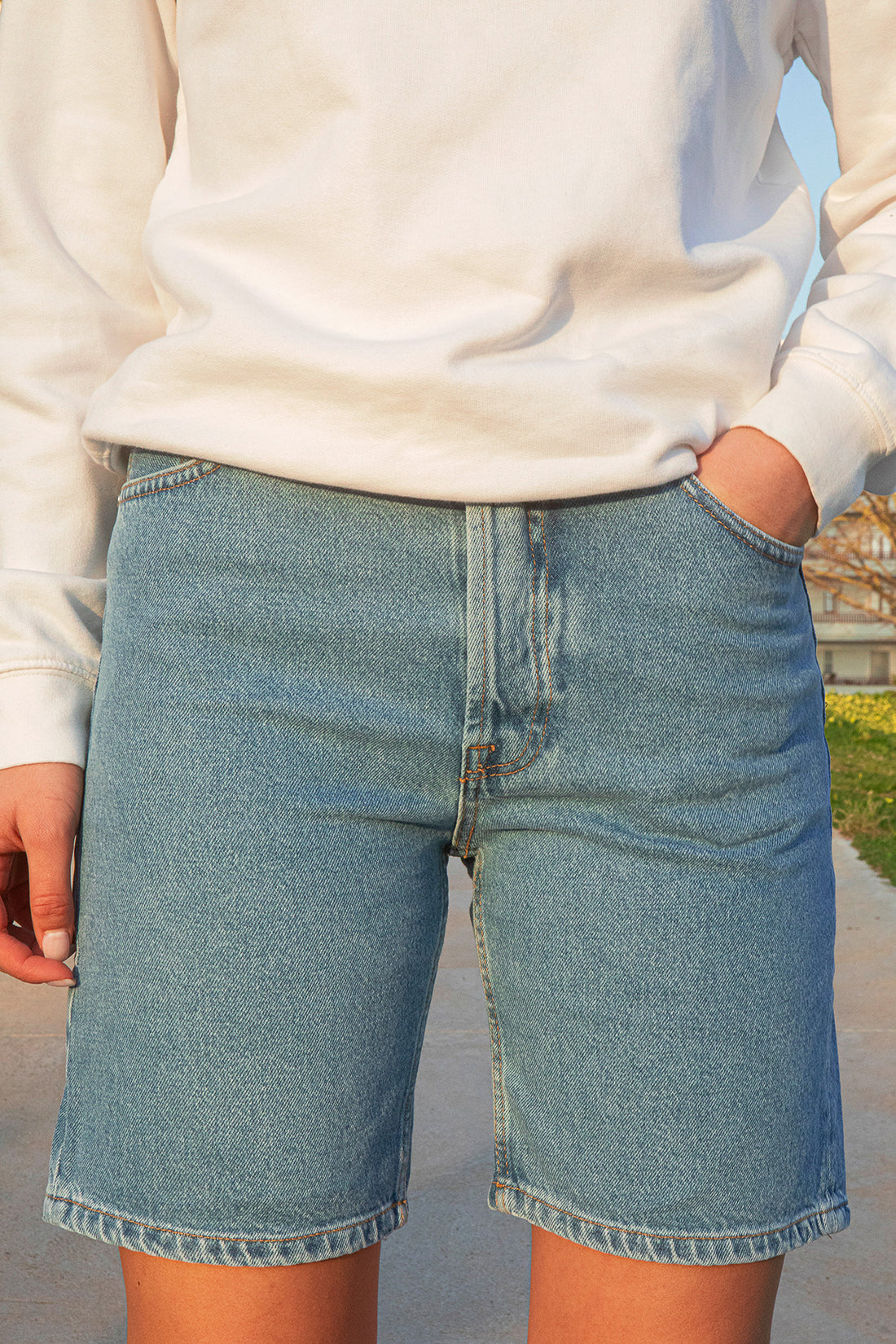 Person wearing blue denim shorts with a blurred background
