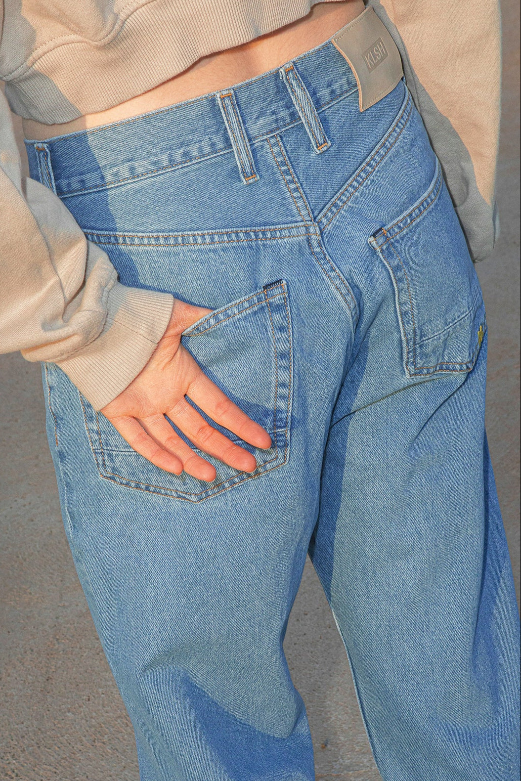 Person wearing blue jeans with a neutral background