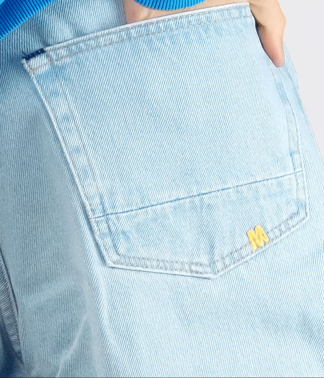 Light blue denim pocket with a brand logo on a light gray background